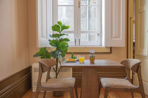une table à manger avec deux chaises et une fenêtre dans l'établissement Dom José Alojamentos by Guestify, à Guimarães