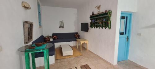 uma sala de estar com um sofá azul e uma mesa em Typique appartement em Houmt Souk