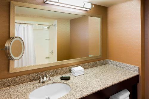 a bathroom with a sink and a mirror at Sheraton Hotel Metairie New Orleans in Metairie