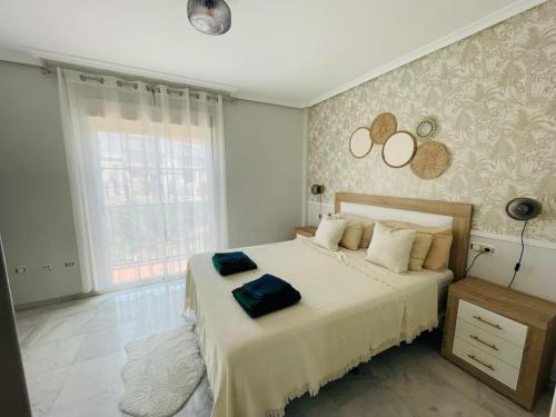 a bedroom with a large bed with a large window at Jolie maison à Cabopino Marbella in Marbella