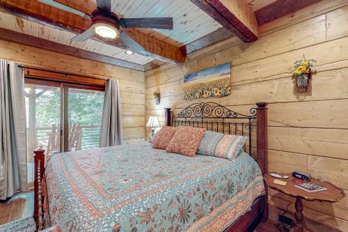 a bedroom with a bed and a wooden wall at Tranquil Waters Cabin in Ellijay