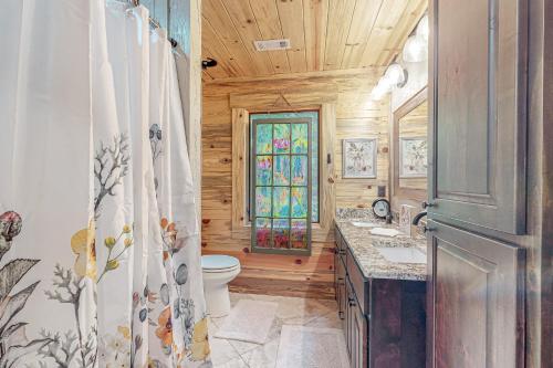 a bathroom with a toilet and a shower curtain at Tranquil Waters Cabin in Ellijay