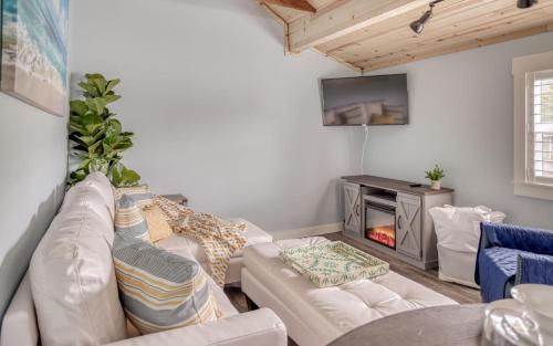 a living room with a white couch and a fireplace at Driftwood - Meredith Lodging in Rockaway Beach