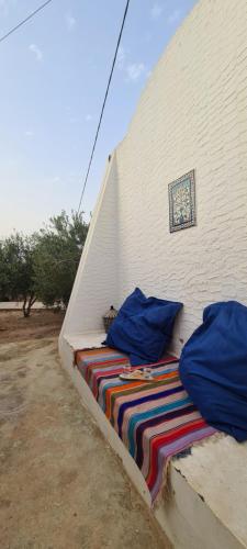 a bed with a colorful blanket on a wall at Typique appartement in Houmt Souk