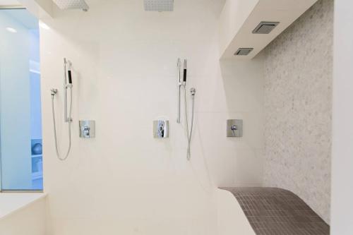 ein Bad mit weißen Wänden und einer ebenerdigen Dusche in der Unterkunft Renaissance Santo Domingo Jaragua Hotel & Casino in Santo Domingo