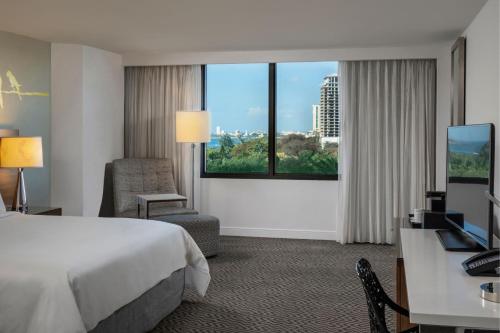 a hotel room with a bed and a desk and a window at Renaissance Santo Domingo Jaragua Hotel & Casino in Santo Domingo