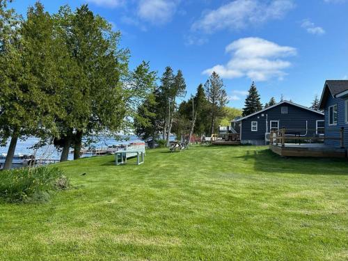 a yard with a picnic table in the grass at Snug Harbour Cottage and Marina in Kawartha Lakes