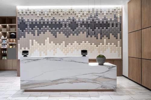 a lobby with a marble counter and a wall of mirrors at AC Hotel by Marriott St Louis Central West End in Saint Louis