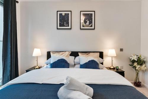 1 dormitorio con 1 cama grande y 2 lámparas en Khayat Homes - The Cosmo - Two Bed, en Londres
