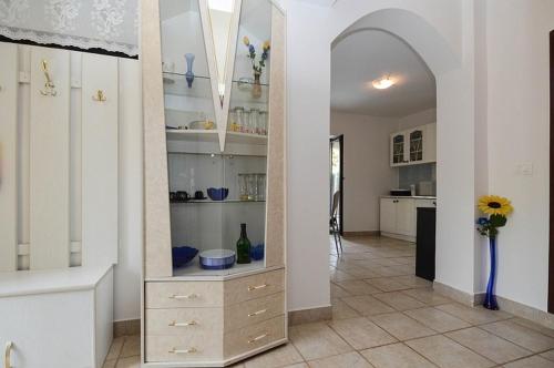 a kitchen with white cabinets and a vase with a sunflower at Apartments with a parking space Pavicini, Marcana - 21315 in Pavicini