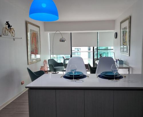 a kitchen with a table with chairs and a blue light at Antofagasta de Lujo-SOLO ADULTOS in Antofagasta