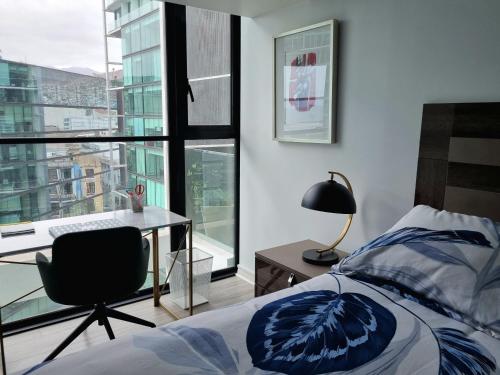 a bedroom with a bed and a desk and a window at Antofagasta de Lujo in Antofagasta