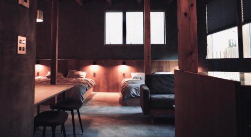 a bedroom with two beds and a table and a chair at MAGATAMA.INN in Sumoto