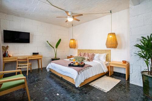 1 dormitorio con 1 cama, escritorio y TV en HOLT - Villa Noria - La Casa del Barro Verde, en Oaxaca City