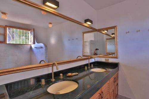 ein Badezimmer mit zwei Waschbecken und einem großen Spiegel in der Unterkunft La villa del sol - pool & spa and staff in Puerto Vallarta