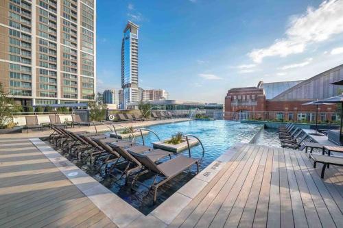 a large swimming pool with chairs and a building at Opulence is a way of life in Dallas
