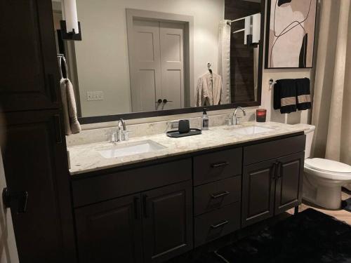 a bathroom with two sinks and a large mirror at Opulence is a way of life in Dallas