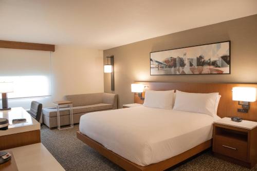a hotel room with a large bed and a chair at Delta Hotels by Marriott Allentown Lehigh Valley in Fogelsville