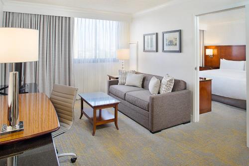 a hotel room with a couch and a bed at Los Angeles Marriott Burbank Airport in Burbank