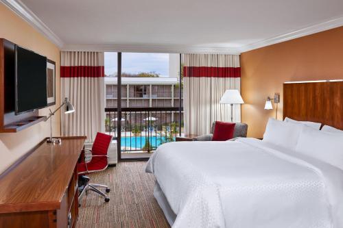 um quarto de hotel com uma cama grande e uma televisão em Four Points by Sheraton Little Rock Midtown em Little Rock