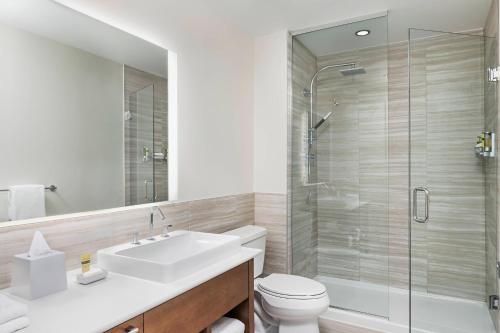 a bathroom with a sink and a toilet and a shower at Element Calgary Airport in Calgary