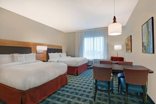 um quarto de hotel com duas camas e uma mesa em TownePlace Suites by Marriott Sarasota/Bradenton West em Bradenton