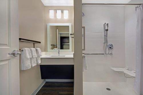 a white bathroom with a sink and a shower at TownePlace Suites by Marriott Sarasota/Bradenton West in Bradenton