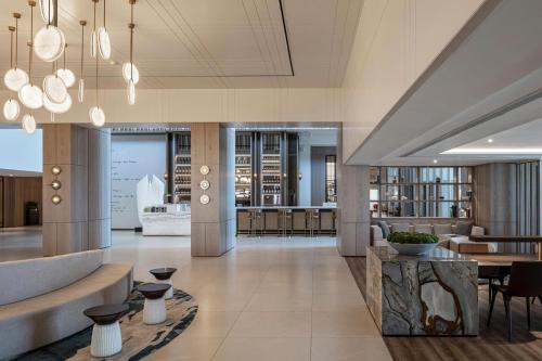 a lobby of a building with tables and chairs at Sheraton Grand Tel Aviv in Tel Aviv