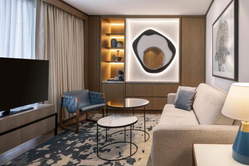 a living room with a couch and a tv at Sheraton Grand Tel Aviv in Tel Aviv
