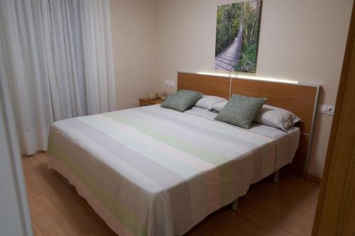 a bedroom with a large bed with two pillows at Àtic Solé in Les Cases d'Alcanar