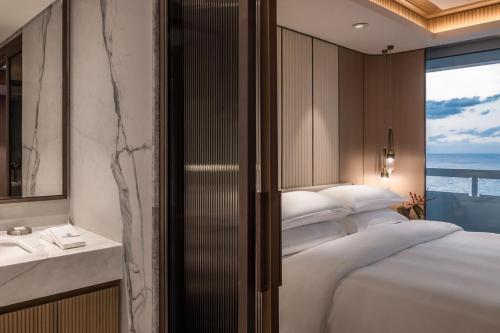 a bedroom with a large white bed and a window at Sheraton Grand Tel Aviv in Tel Aviv