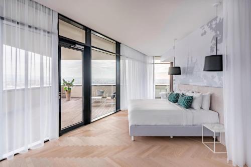 كورتيارد باي ماريوت برنو في برنو: غرفة نوم بيضاء مع سرير وشرفة
