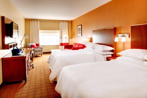 een hotelkamer met 3 bedden en een bank bij Four Points by Sheraton Oklahoma City Quail Springs in Oklahoma City