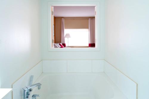 a bathroom with a mirror and a sink at Four Points by Sheraton Oklahoma City Quail Springs in Oklahoma City