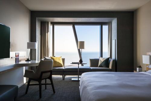 Cette chambre comprend un lit, un bureau et un canapé. dans l'établissement Marriott Marquis Chicago, à Chicago