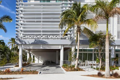 a building with palm trees in front of it at AC Hotel by Marriott Fort Lauderdale Beach in Fort Lauderdale