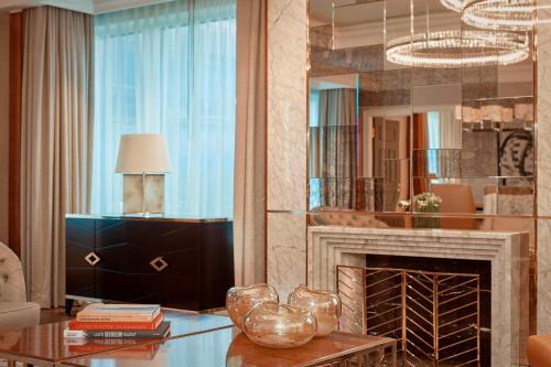 a living room with a fireplace and a mirror at The Ritz-Carlton, Berlin in Berlin