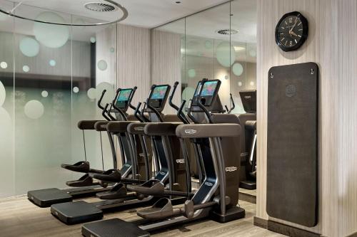a row of exercise bikes in a gym with a clock at The Ritz-Carlton, Berlin in Berlin
