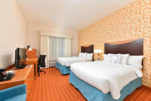 a hotel room with two beds and a television at Fairfield Inn & Suites Kingsland in Kingsland