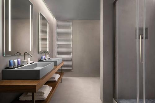 a bathroom with two sinks and a shower at Grand Universe Lucca, Autograph Collection in Lucca
