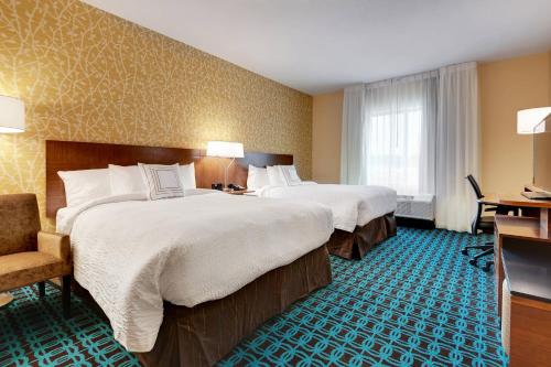 um quarto de hotel com duas camas e uma cadeira em Fairfield Inn by Marriott Houston Northwest/Willowbrook em Houston