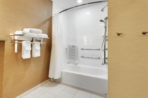 uma casa de banho com um chuveiro e toalhas brancas em Fairfield Inn by Marriott Houston Northwest/Willowbrook em Houston