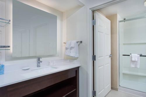 La salle de bains blanche est pourvue d'un lavabo et d'un miroir. dans l'établissement Residence Inn Knoxville Cedar Bluff, à Knoxville