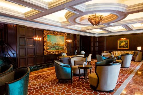 The Ritz-Carlton, Kuala Lumpur في كوالالمبور: مطعم فيه كراسي وطاولات وثريا