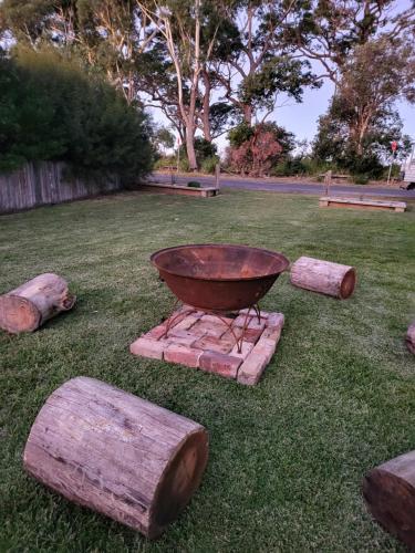 a bowl sitting on top of a field with logs at Husky 56 Beachfront Villa's - great location on the beach in Huskisson