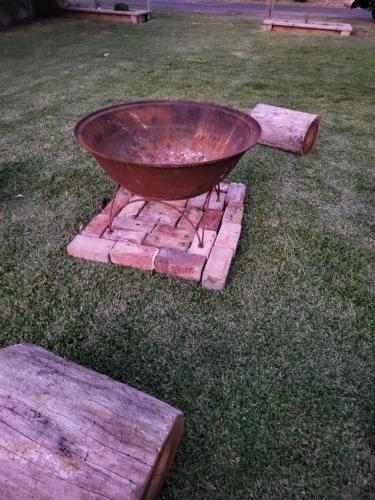 a grill sitting on top of some logs in the grass at Husky 56 Beachfront Villa's - great location on the beach in Huskisson