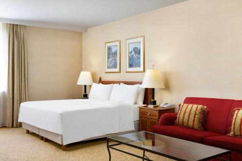 een hotelkamer met een bed en een rode bank bij Millennium Court, Budapest - Marriott Executive Apartments in Boedapest