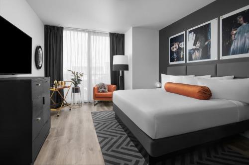 - une chambre avec un grand lit blanc et une télévision dans l'établissement The ENGLiSH Hotel, Las Vegas, a Tribute Portfolio Hotel, à Las Vegas
