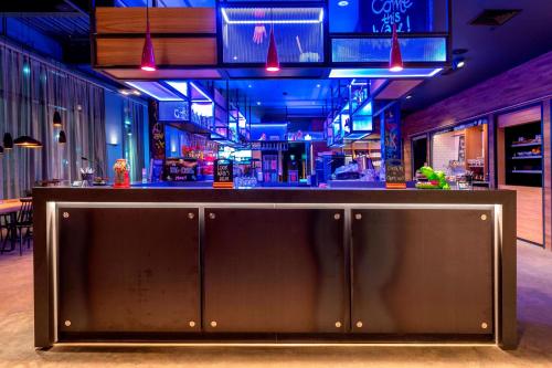 a bar in a restaurant with blue lights at Moxy Glasgow Merchant City in Glasgow