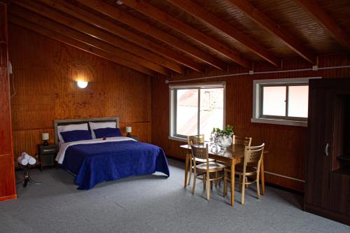 1 dormitorio con 1 cama, mesa y sillas en Hotel Gran Luna, en Puerto Montt